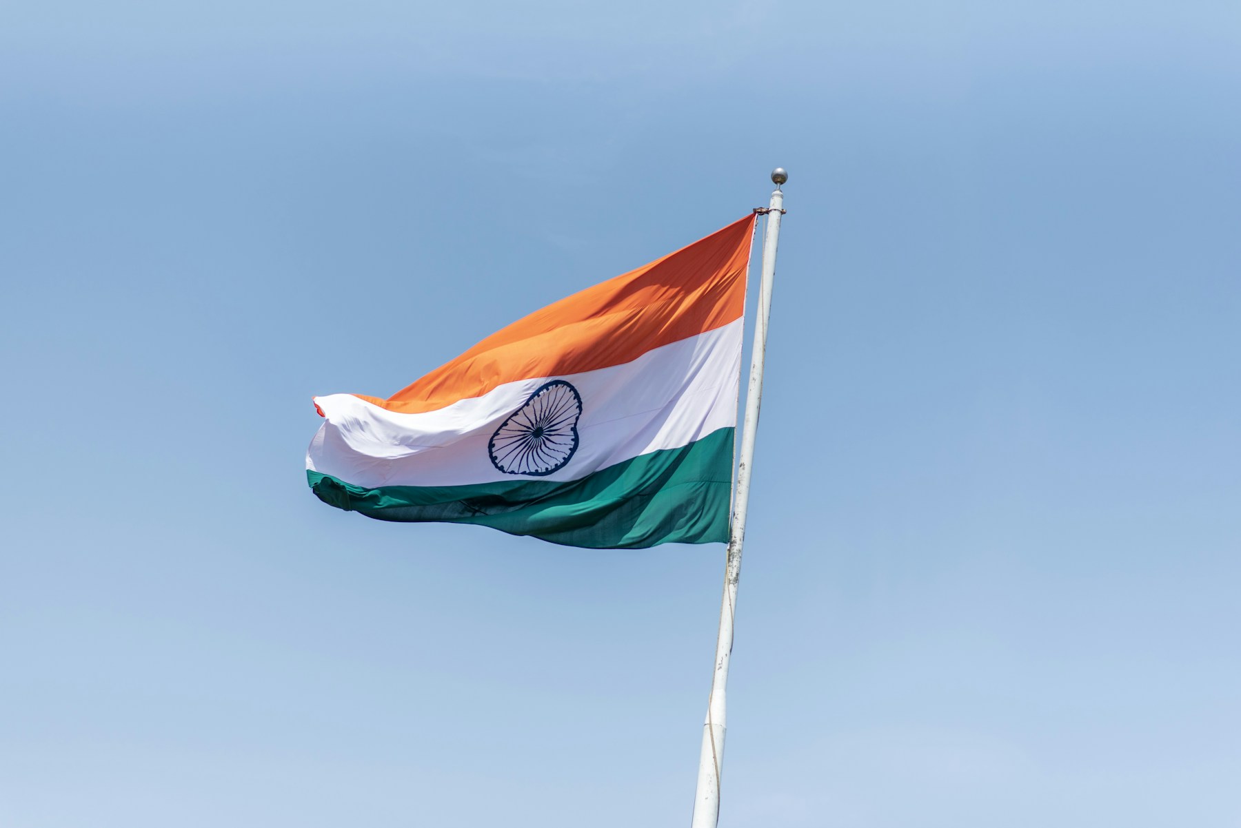 The Indian tricolour waving against a blue sky